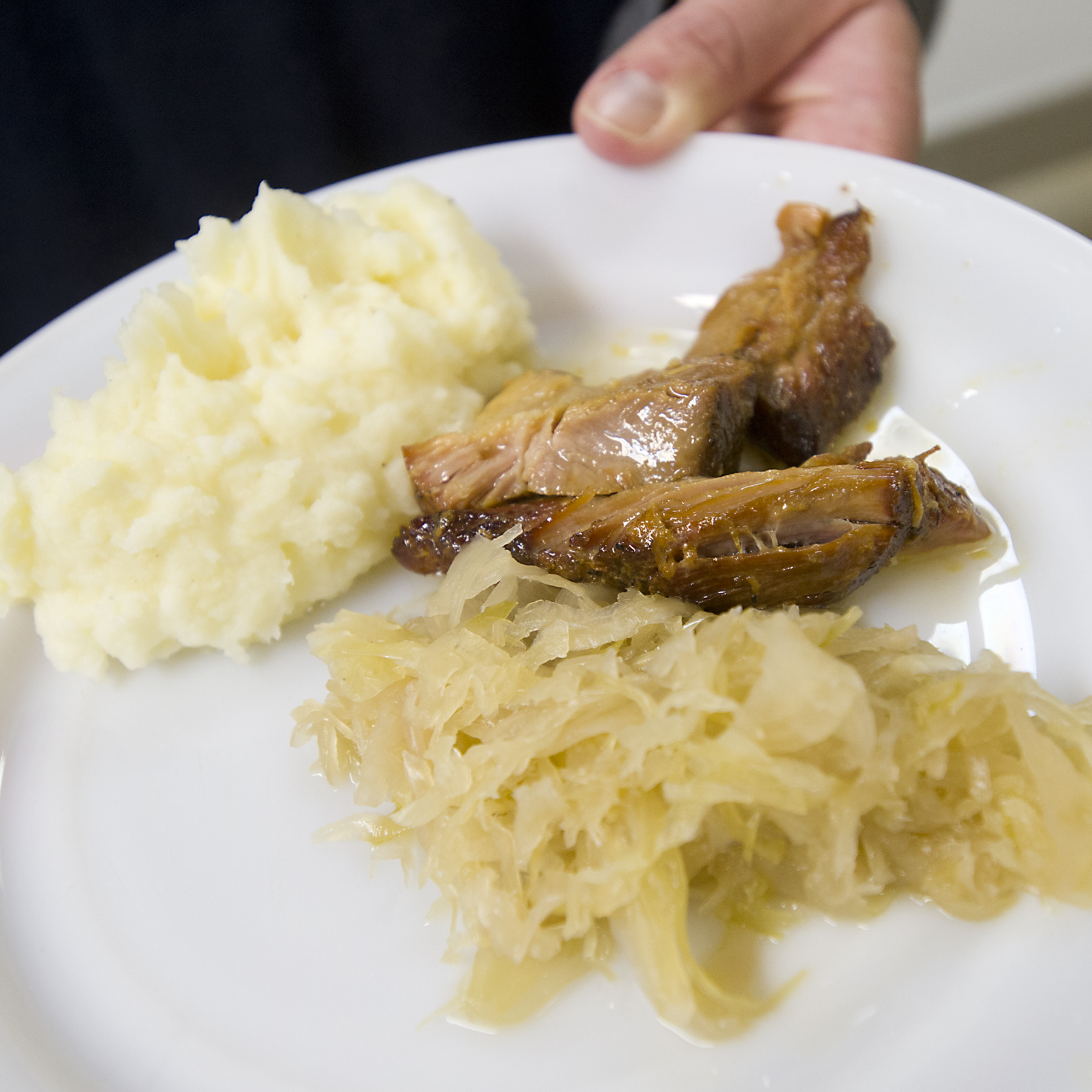Volunteer June McCracken of South Whitehall Township serves a platter of pork and sauerkraut with mashed potatoes during a fundraising dinner at Emmanuel United Church of Christ of Allentown on New Year’s Day, Jan. 1, 2018. (Harry Fisher/The Morning Call)

