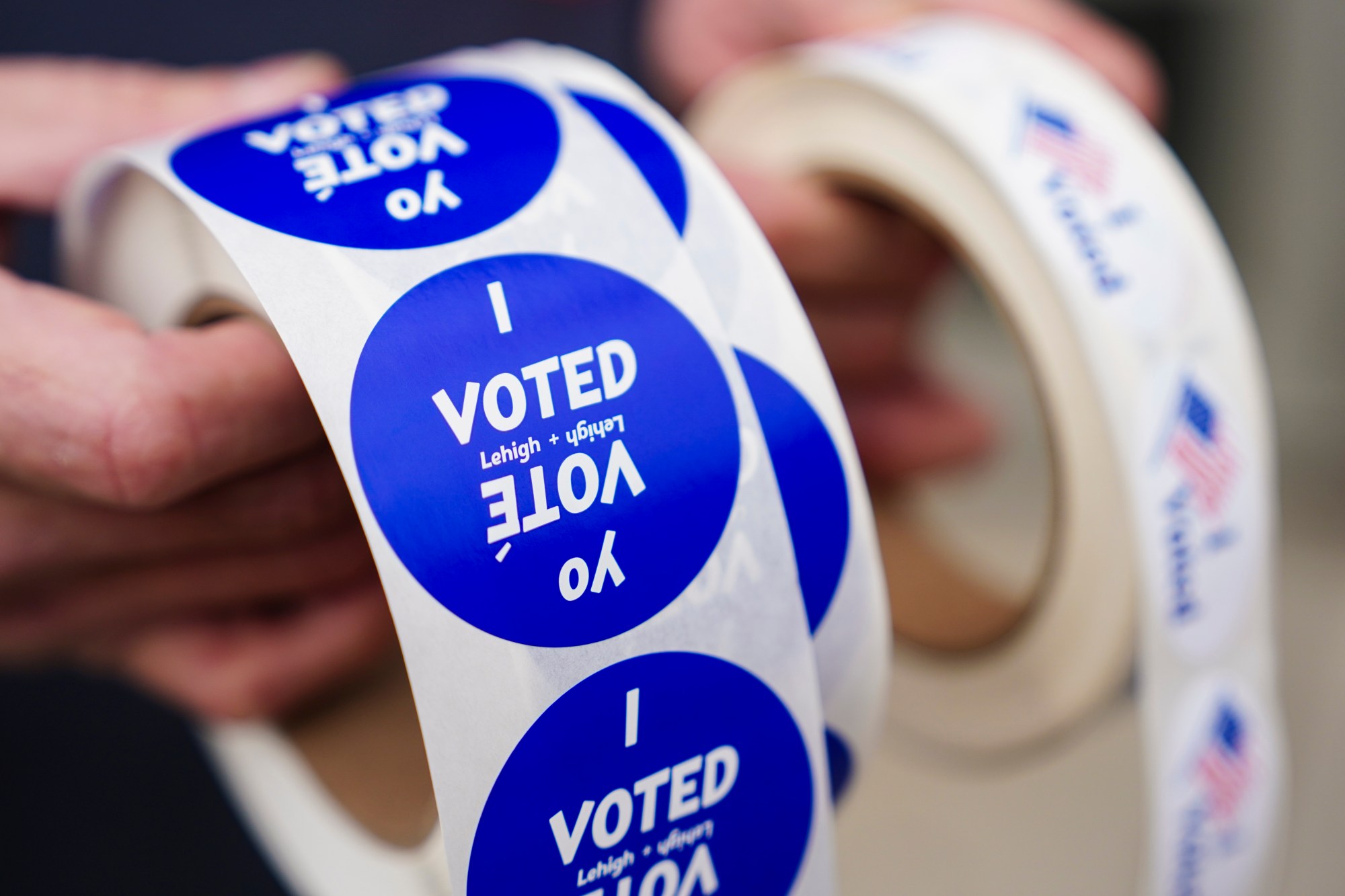 A poll worker holds voting stickers for community members Nov. 7, 2023, at Central Elementary School in Allentown. (Matt Smith/For Spotlight PA)
